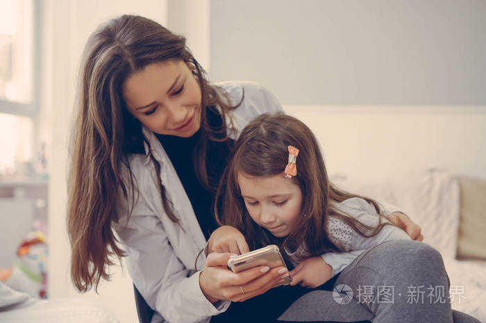 妈妈和女儿正在看智能手机