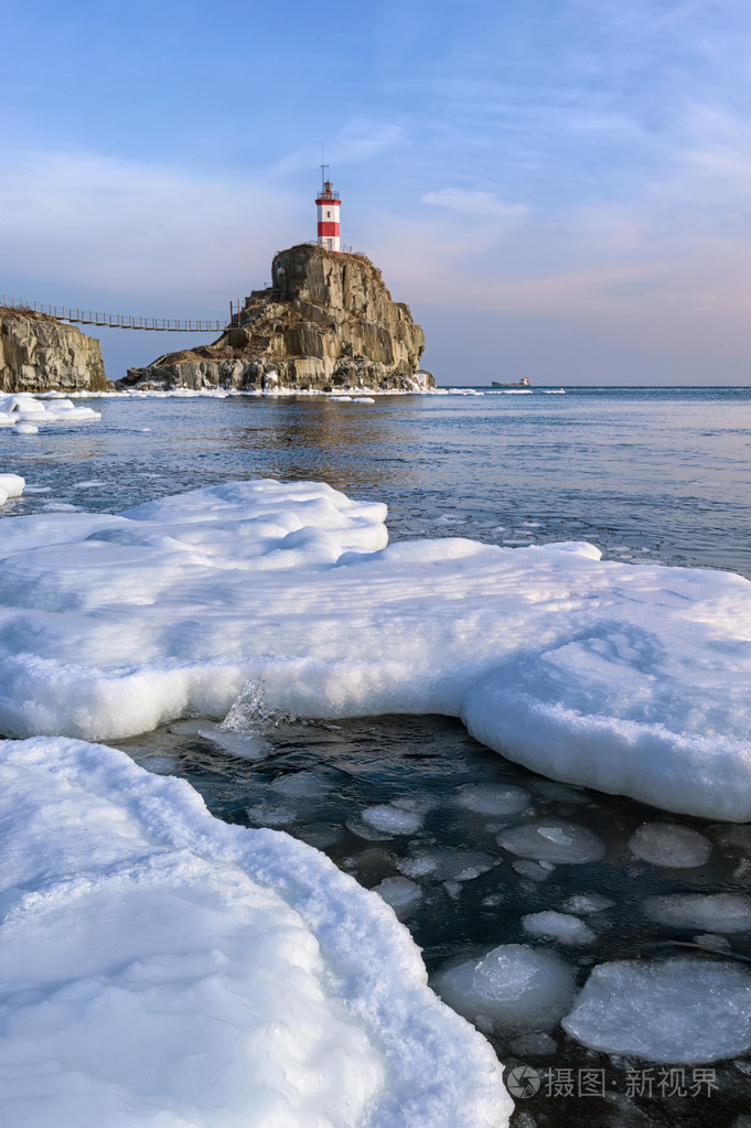 冬天图片灯塔一块孤独的石头上.东 (日本) 海