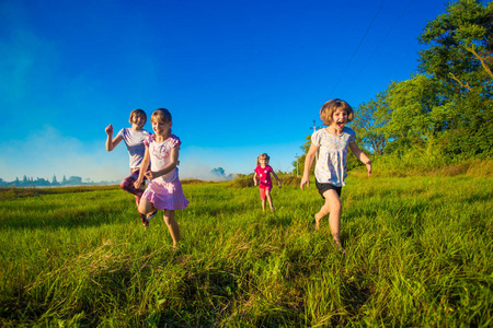 一群快乐的孩子在绿色的夏日奔跑