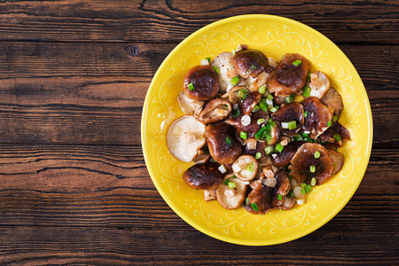 青葱炒蘑菇, 木质背景。中国菜。顶部视图。平躺