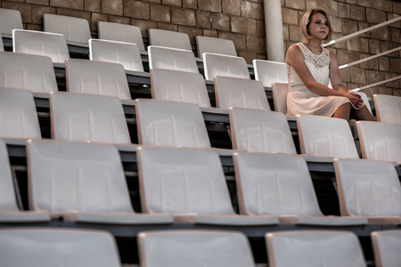 一个美丽的年轻女子在体育场的肖像。寂寞的风扇