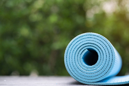 桌面上的蓝色瑜伽垫, 运动和健康概念的特写