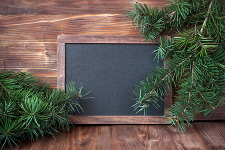 圣诞节木制背景与黑板和冷杉树枝