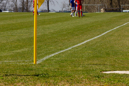 业余足球场与绿色草坪和白色线与黄杆在角落边缘