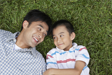 父亲和儿子躺在草地上