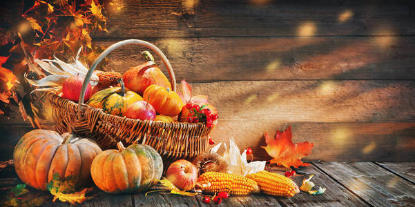 感恩节南瓜水果和落叶在质朴的木桌上
