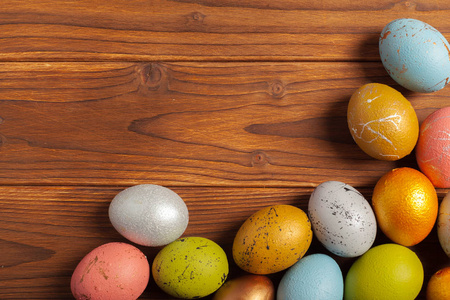 木制背景上的七彩复活节彩蛋。