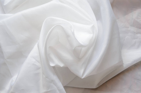 白色合成衬里织物与褶皱.皱巴巴的床单或衣服背景照片