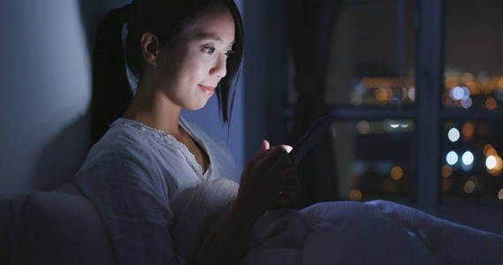 女人在晚上使用手机忘在家里照片