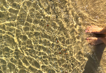 妇女脚在水在黄海沙子