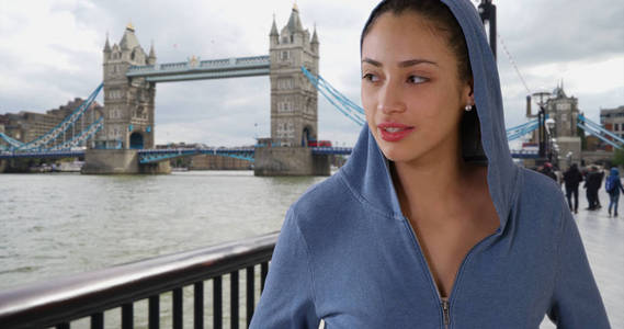 在伦敦的塔桥附近, 有思想的年轻拉丁妇女站在