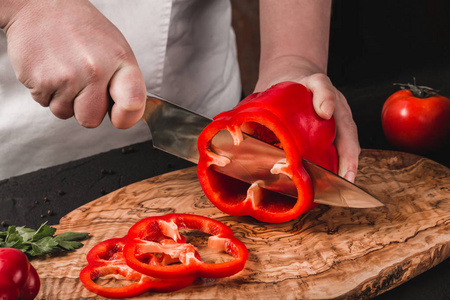 厨师用刀在厨房切菜, 烹调食物.餐桌上的配料.健康食品概念.