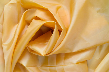 黄色合成衬里织物与褶皱。皱巴巴的床单或衣服背景