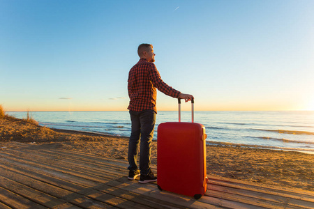 自然, 旅行, 人的概念一个人站在海边与红色手提箱
