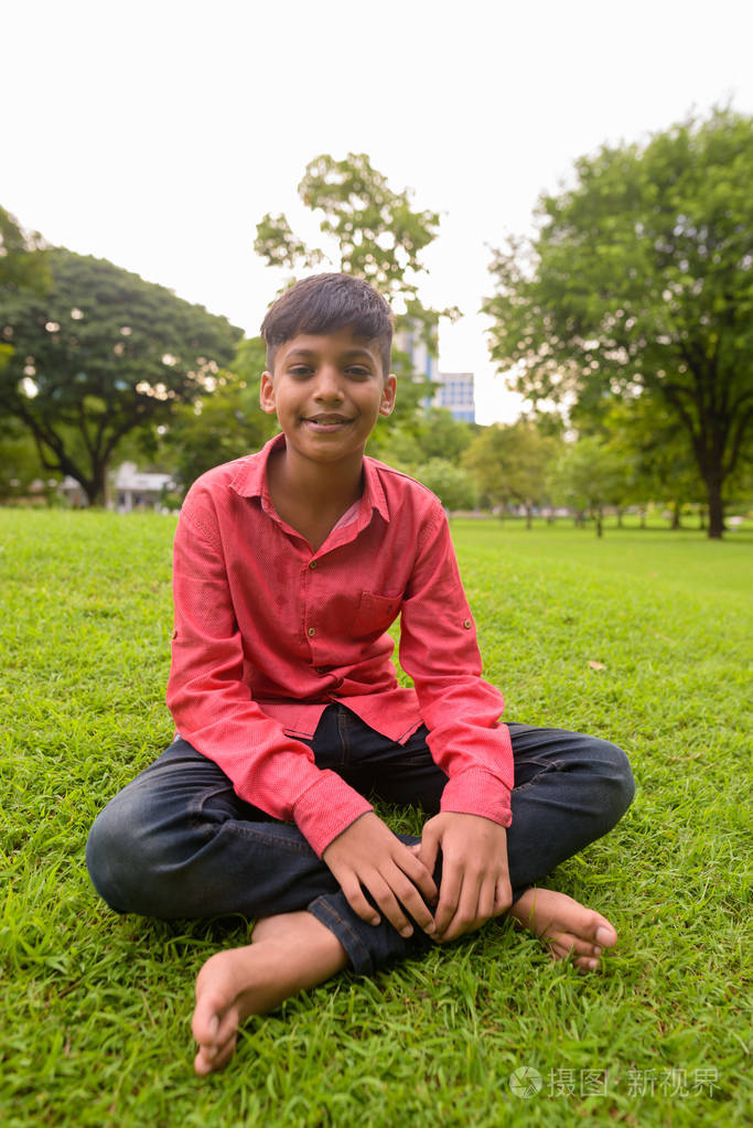 在公园放松的年轻的印度男孩的画像