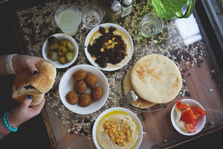 以色列在耶路撒冷的咖啡馆里吃了一顿以色列午餐。Falafels 在一个盘子上, 奶油鹰嘴豆与整个 cheakpeas, 皮塔饼和