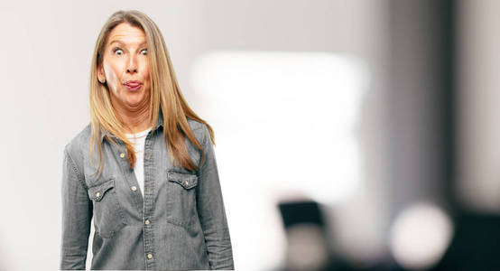 高级美女开玩笑, 用滑稽, 愚蠢和俏皮的表情贴舌头, 看起来像个傻瓜