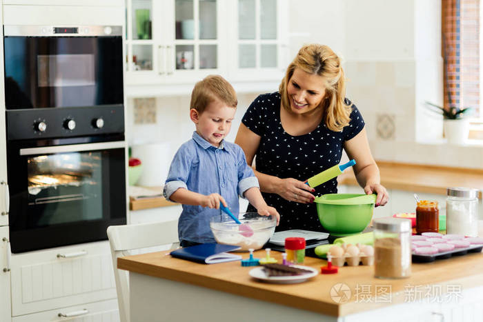 孩子帮助母亲做饼干在现代厨房