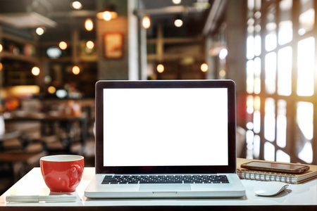 在咖啡店和餐厅的办公室和背景上, 杯子和笔记本电脑的前视图