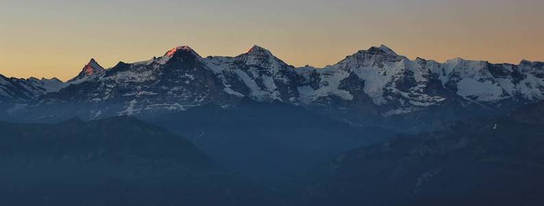 从 niederhorn 山的看法, 瑞士。著名的山 Eiger, Monch 和少女峰渡在日出