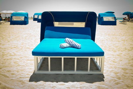 豪华沙滩床与冠层在沙滩上图片