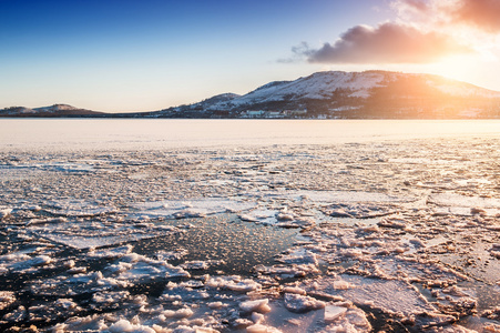 冰和雪的湖上的日落