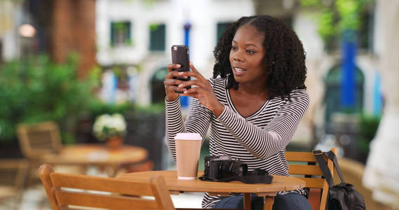 美丽的黑人女性的肖像坐在户外咖啡馆在威尼斯拍照