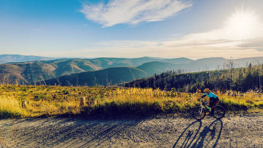 骑自行车的妇女在秋天的山森林风景。骑自行车 mtb 流动小道轨道的妇女。户外运动活动