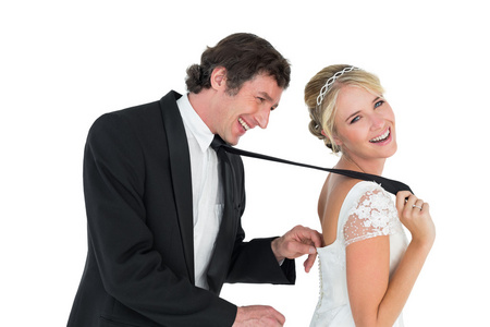 新娘拉领带顽皮的新婚夫妇照片