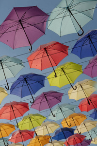 明亮的五颜六色的雨伞挂在绳子上蓝天背景