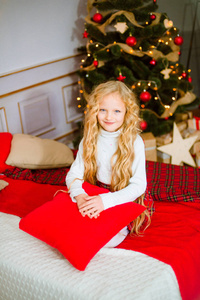 圣诞节早上金发碧眼卷发的小女孩。圣诞快乐小女孩为圣诞礼物而欣喜