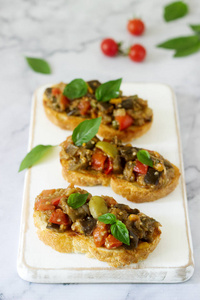 Bruschetta 与 caponata 或炖菜从不同的蔬菜在一个光的背景。选择性聚焦