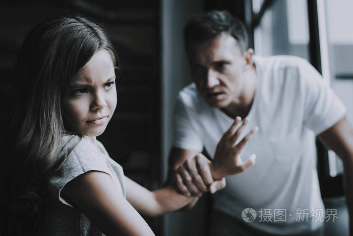 家里的父亲和女孩吵架亲属的肖像责骂和争吵在室内愤怒的人抱着女儿的