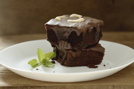 自制的黑巧克力布朗尼, 上面放着腰果和薄荷, 上面堆满了复制空间的木桌。布朗尼是一种巧克力蛋糕