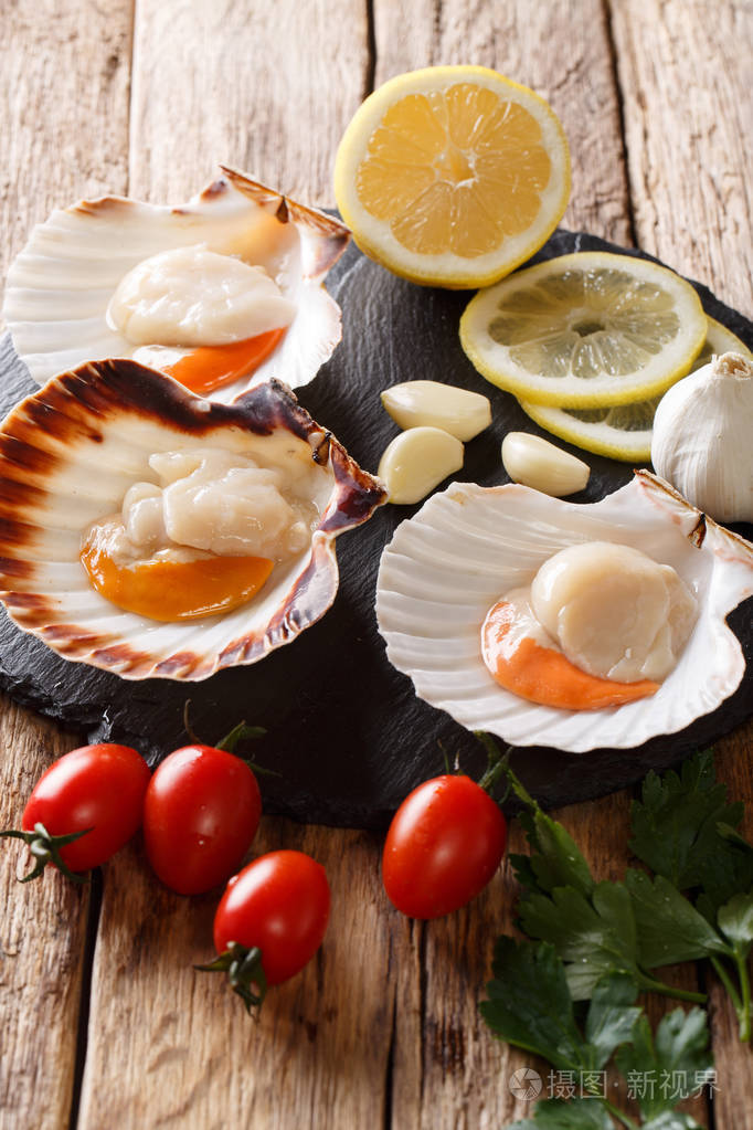 新鲜的扇贝在一个贝壳与蔬菜成分特写在桌子上vertica