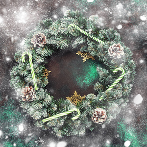 圣诞节或新年框架组成与花圈和绿色的雪杉木树枝, 松树锥, 金色的雪花, 圣诞节糖果棍子棕色背景, 顶部视图