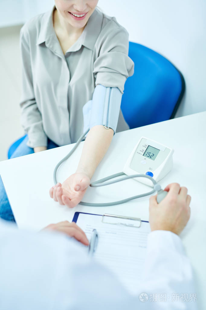 高角度视图在无法辨认的医生测量血压使用眼压计在室复制空间