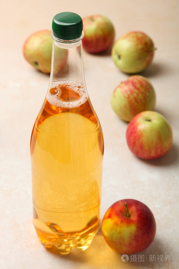 苹果酒在瓶和苹果在中性背景.概念酒精饮料