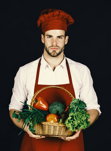 勃艮第制服的主厨拿着蔬菜柳条篮