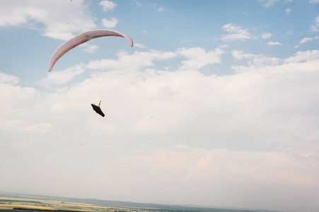 一只白色橙色的滑翔伞飞越山地地形