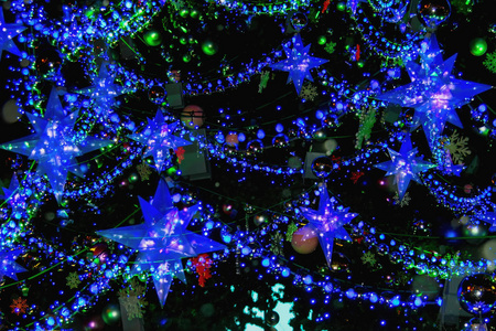 圣诞树上有装饰品, 圣诞明星, 雪花, 球, 花环。抽象节日背景。明亮的蓝色背景为设计
