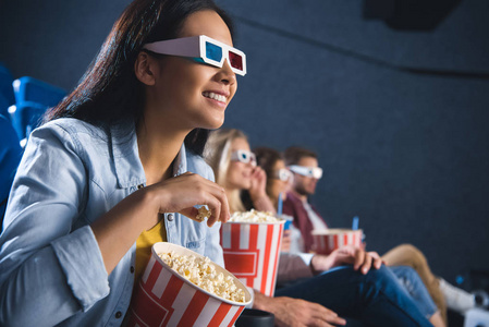 3d 眼镜的亚洲女人微笑着看电影的爆米花照片