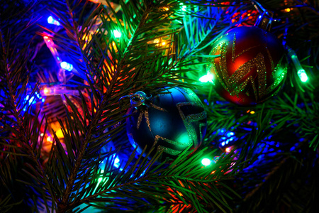 圣诞玩具在五颜六色的灯光中树枝上的金色球。祝贺新年和圣诞节