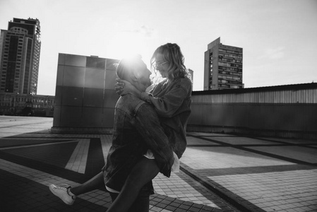 黑色和白色的天空一对年轻的成年夫妇拥抱在城市街道上的天空, 黑色和