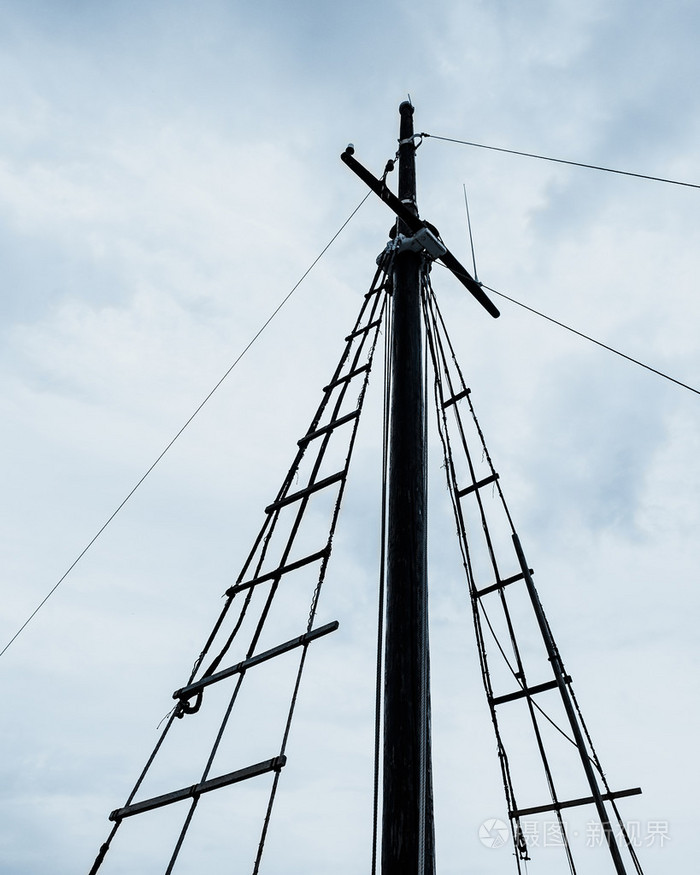 简单船的桅杆对面多云的天空