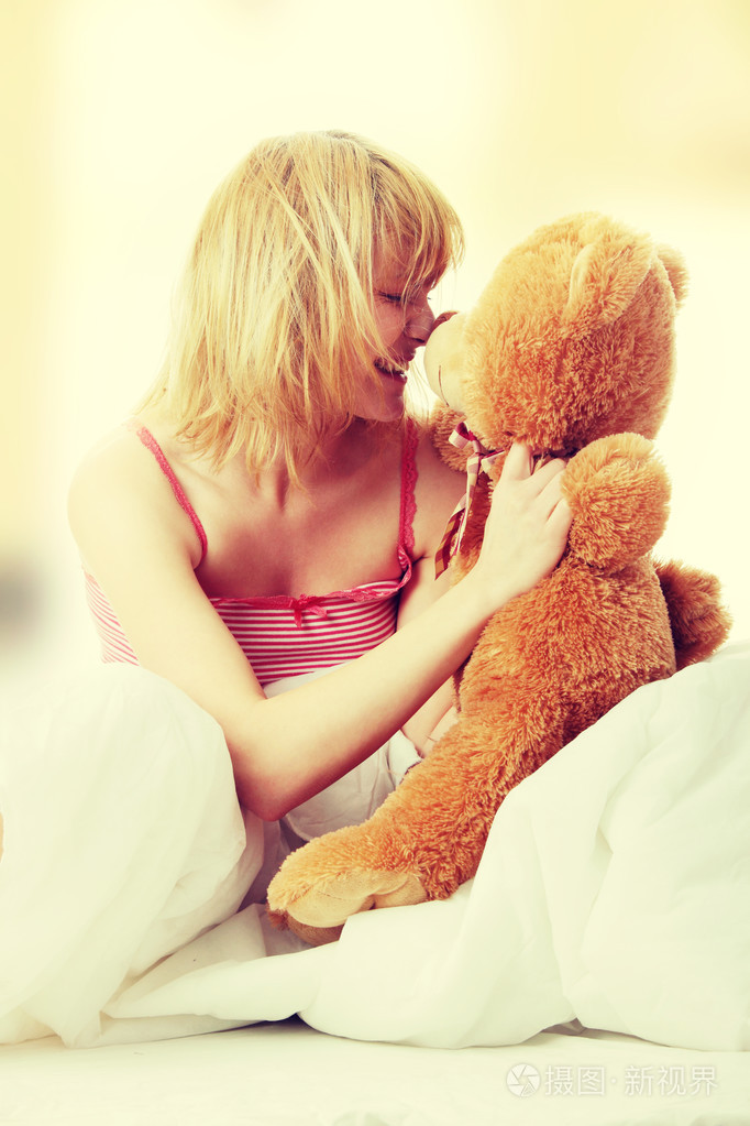 女人在床上拥抱泰迪熊
