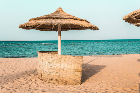 海滩遮阳伞由天然材料从棕榈树的海洋