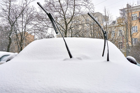 寒冷的冬天在积雪覆盖的汽车谨慎地解除了挡风玻璃雨刷, 不会落到杯子