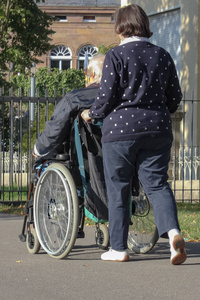 夫人与高级男子在轮椅在城市公园秋季晚上在德国南部