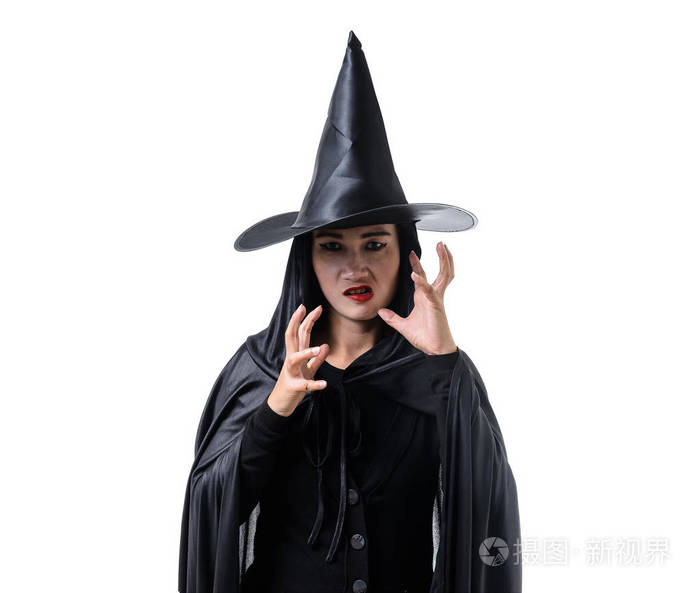 照片 在黑色可怕的女巫万圣节服装的肖像站在白色背景的帽子和喃喃的